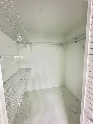 a large white kitchen with a stove a refrigerator and a refrigerator