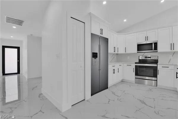 a kitchen with stainless steel appliances a refrigerator sink and cabinets