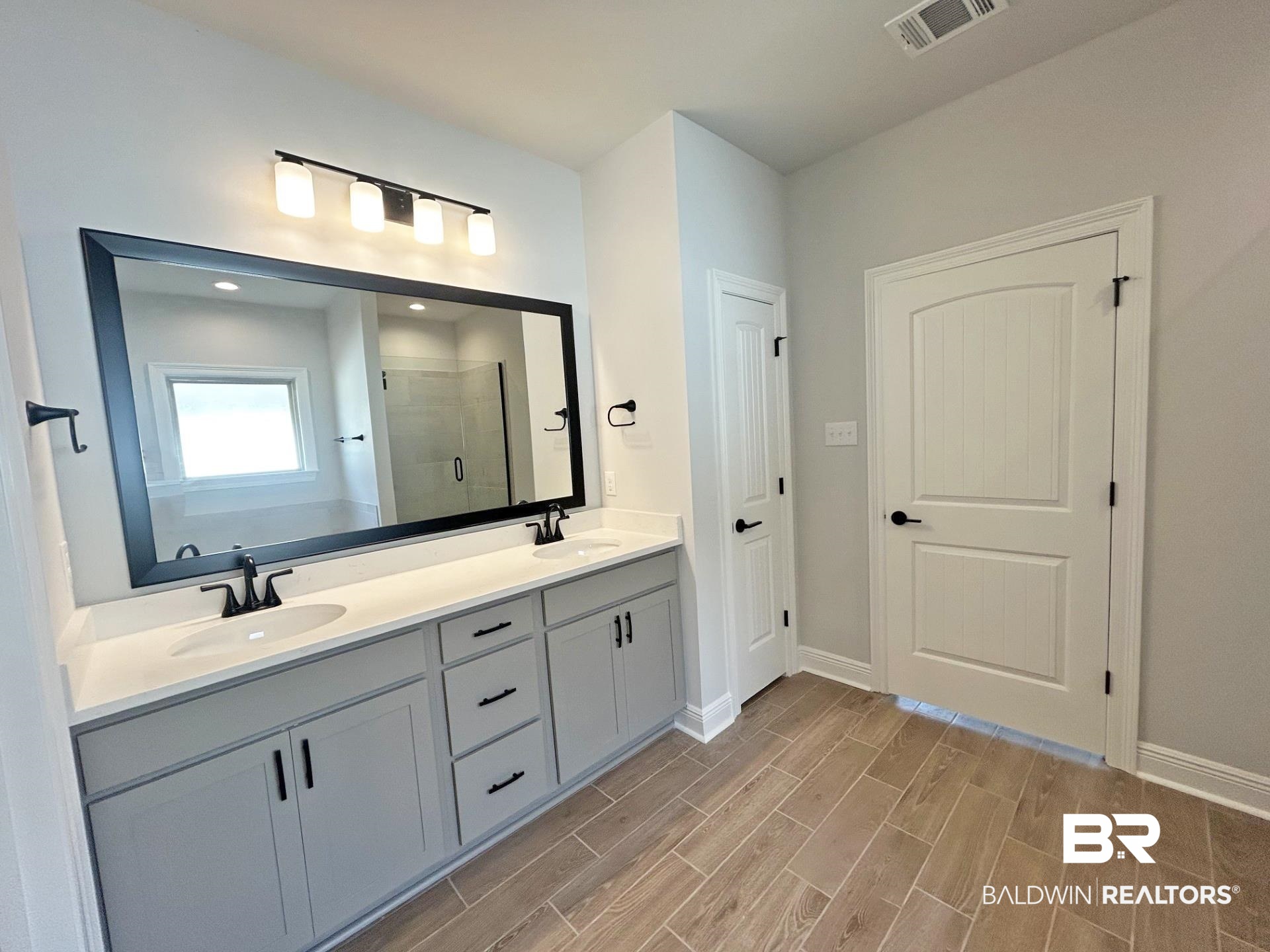 825 Sumter Loop Foley, AL 36535 - Photo 9 of 21 Bathroom with double vanity, wood finish floors, and a stall shower