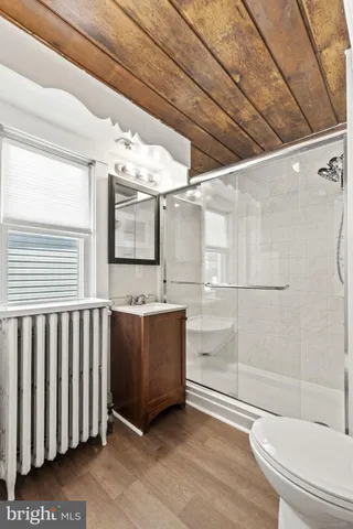 a bathroom with a granite countertop sink a toilet and shower
