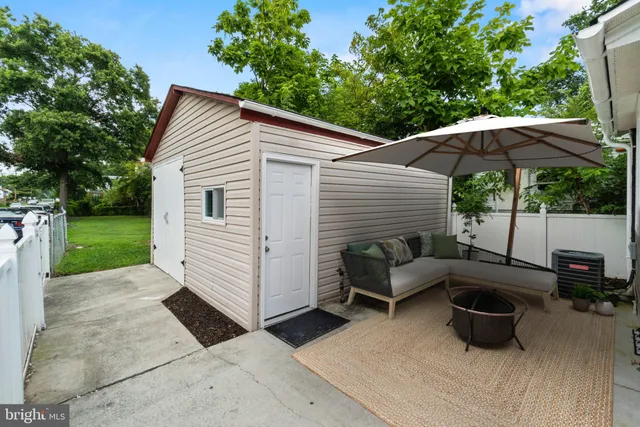 a view of a patio with couches chairs under an umbrella