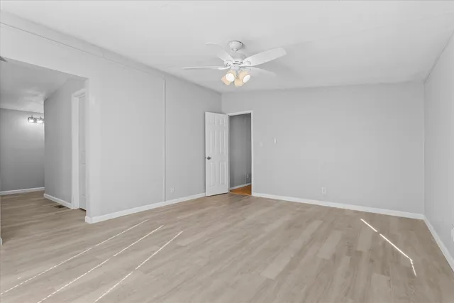 a view of an empty room with wooden floor