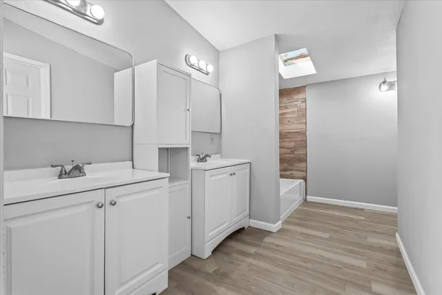 a room with a sink cabinets and wooden floor