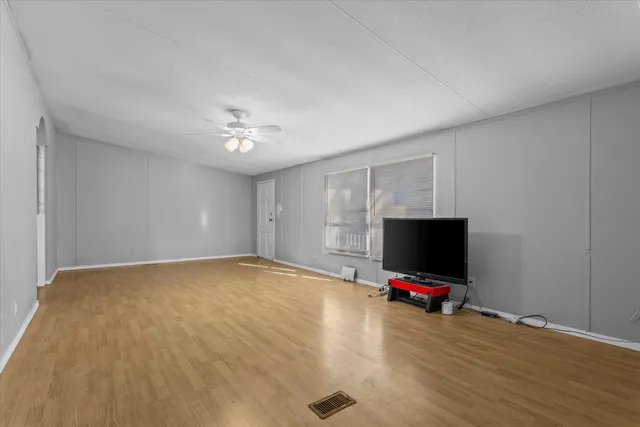 a view of room with wooden floor and flat screen tv