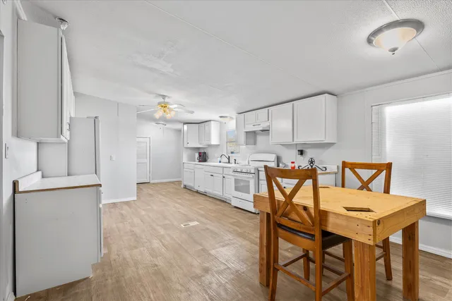 a kitchen with stainless steel appliances a table and chairs in it
