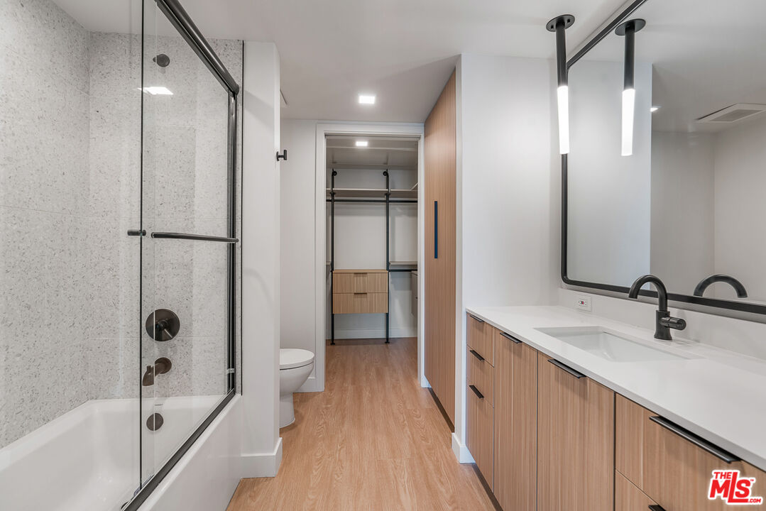 3688 Overland Avenue, Unit PH14 Los Angeles, CA 90034 - Photo 14 of 37 a bathroom with a double vanity sink a toilet and shower
