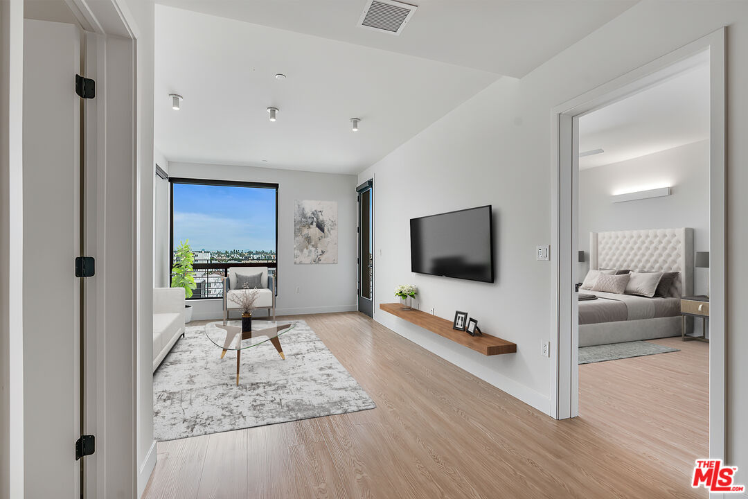 3688 Overland Avenue, Unit PH14 Los Angeles, CA 90034 - Photo 7 of 37 a living room with furniture and a flat screen tv