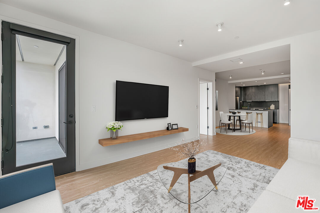 3688 Overland Avenue, Unit PH14 Los Angeles, CA 90034 - Photo 8 of 37 a living room with furniture and a flat screen tv