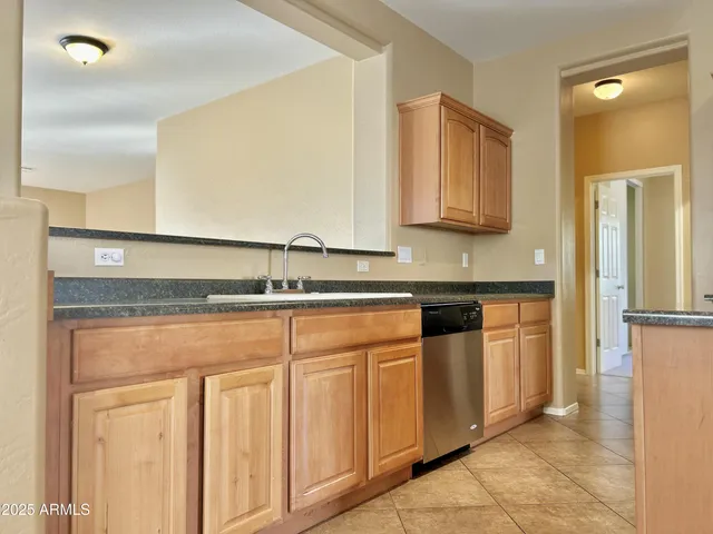 a kitchen with stainless steel appliances granite countertop a sink and a refrigerator