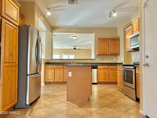 a kitchen with stainless steel appliances granite countertop a refrigerator and a sink