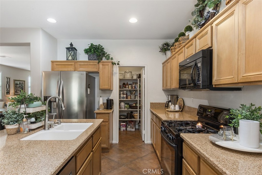 32095 Zion Way Winchester, CA 92596 - Photo 11 of 30 a kitchen with stainless steel appliances granite countertop a sink stove and refrigerator