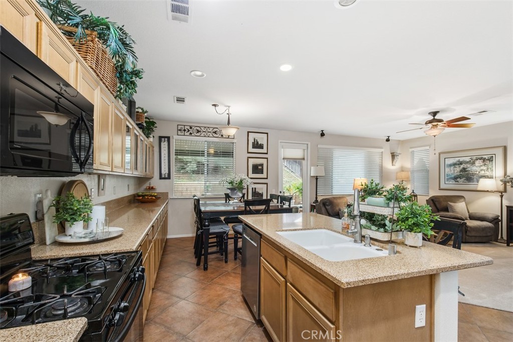 32095 Zion Way Winchester, CA 92596 - Photo 15 of 30 a kitchen with stainless steel appliances granite countertop a sink a stove and a refrigerator