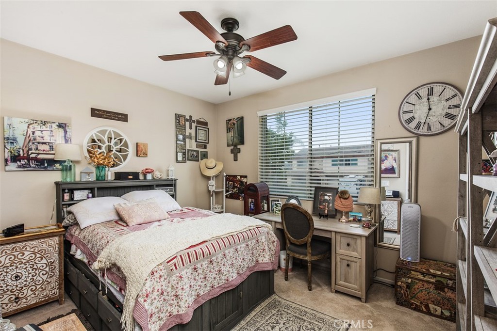 32095 Zion Way Winchester, CA 92596 - Photo 16 of 30 a bedroom with a bed a clock on dresser and a large window