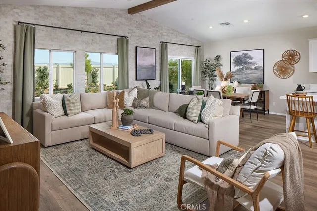 a living room with furniture wooden floor and a large window