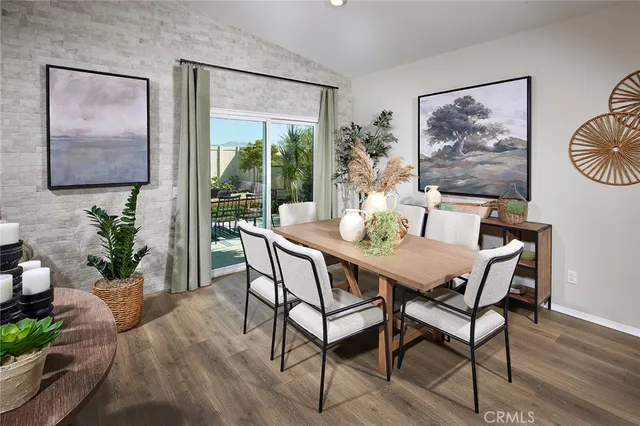 a dining room with furniture potted plants and wooden floor