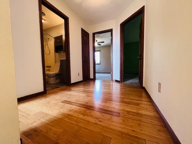 a view of a hallway with wooden floor and closet