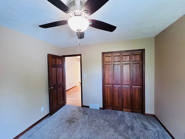 an empty room with closet and windows
