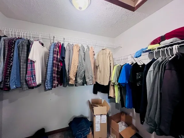 a view of walk in closet with clothes and shoes