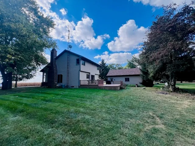 a view of a house with a big yard and large trees