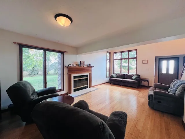 a living room with furniture a fireplace and a floor to ceiling window
