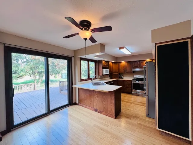 a kitchen with stainless steel appliances granite countertop a stove and a view of living room