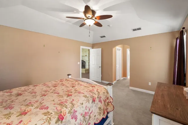 a bedroom with a bed and a ceiling fan