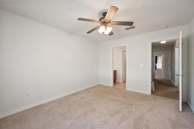 an empty room and chandelier fan