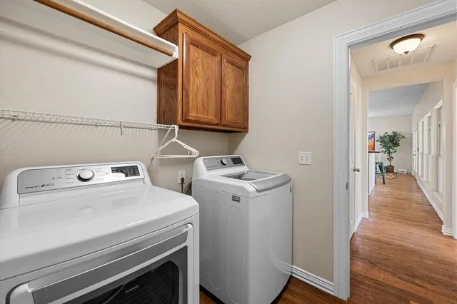 a view of washer and dryer with wooden floor