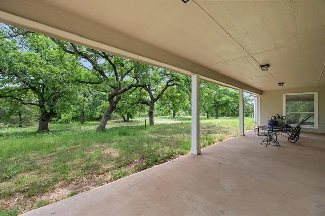 a view of a backyard with sitting area and garden