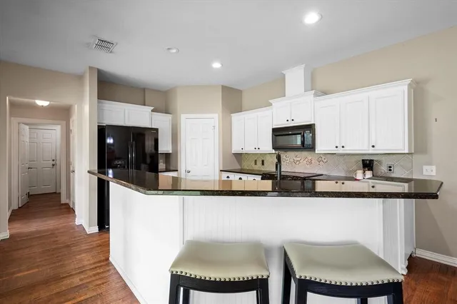 a kitchen with stainless steel appliances kitchen island granite countertop a sink and cabinets