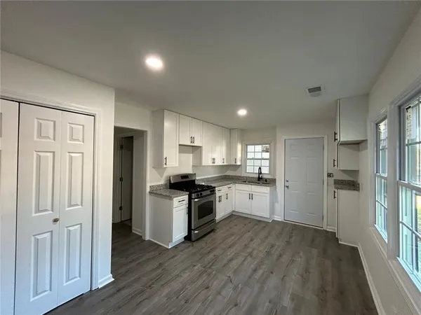 a kitchen with a refrigerator and a stove top oven