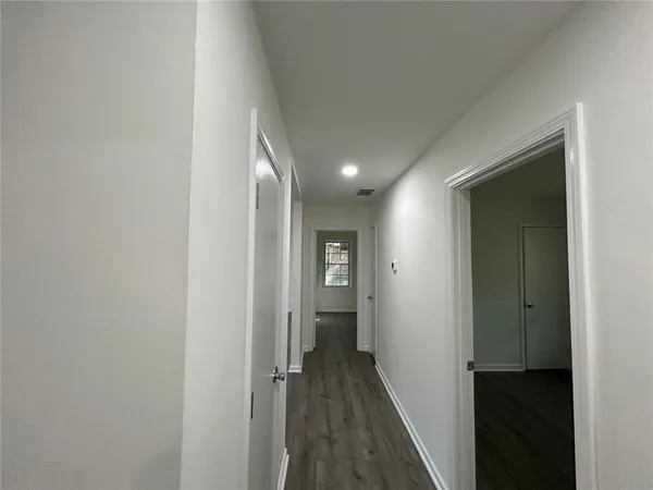 a view of a hallway with a hardwood
