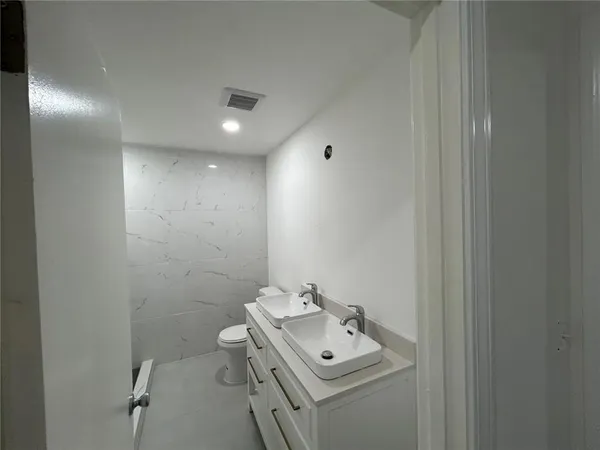 a bathroom with a toilet a sink a vanity and mirror