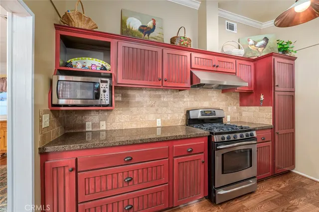 a kitchen with stainless steel appliances granite countertop a stove a microwave and cabinets
