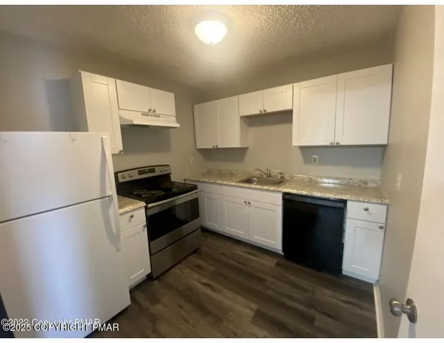 a kitchen with a white cabinets and white appliances