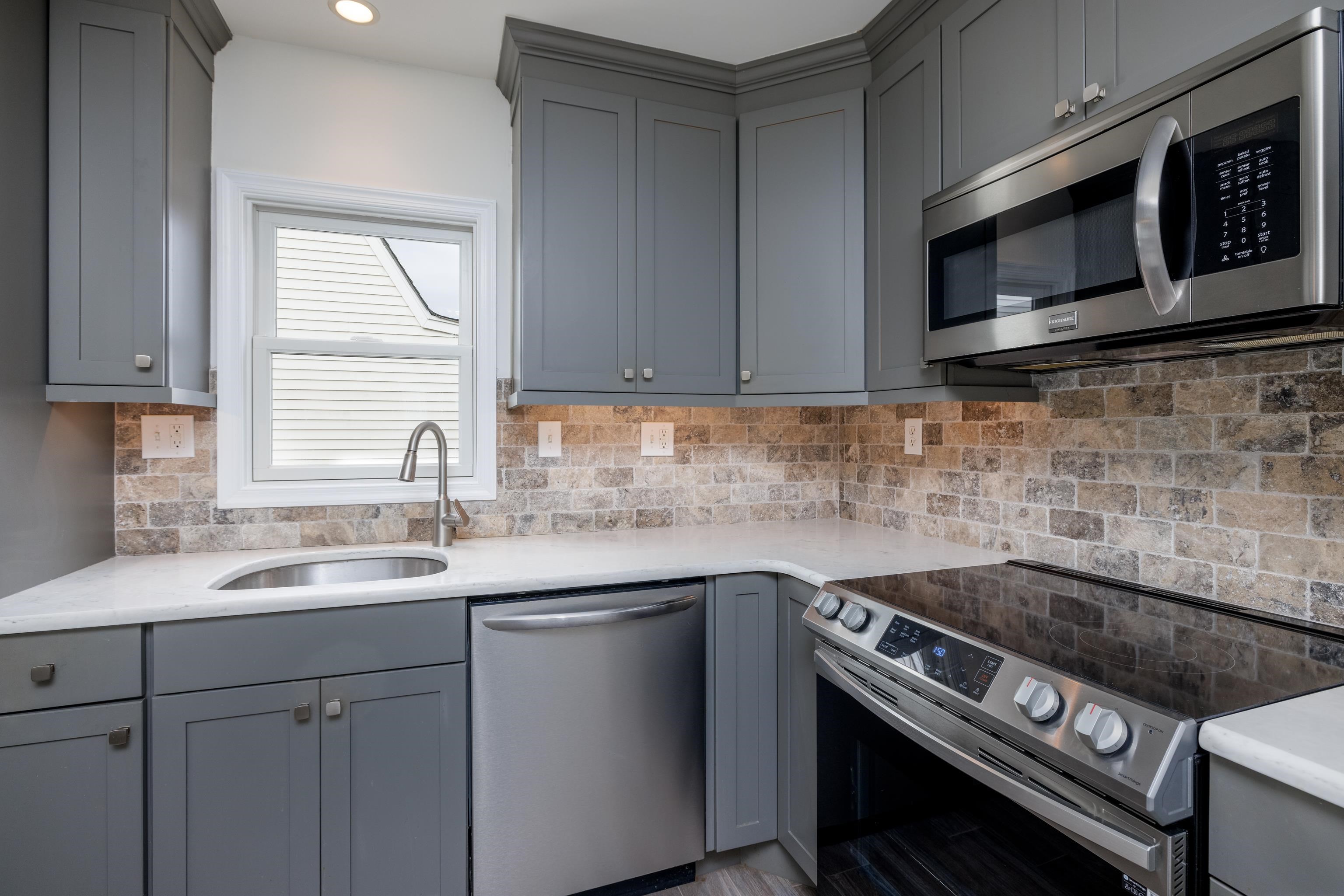 121 Broadway Villas, NJ 08251 - Photo 6 of 32 a kitchen with stainless steel appliances a sink stove and microwave