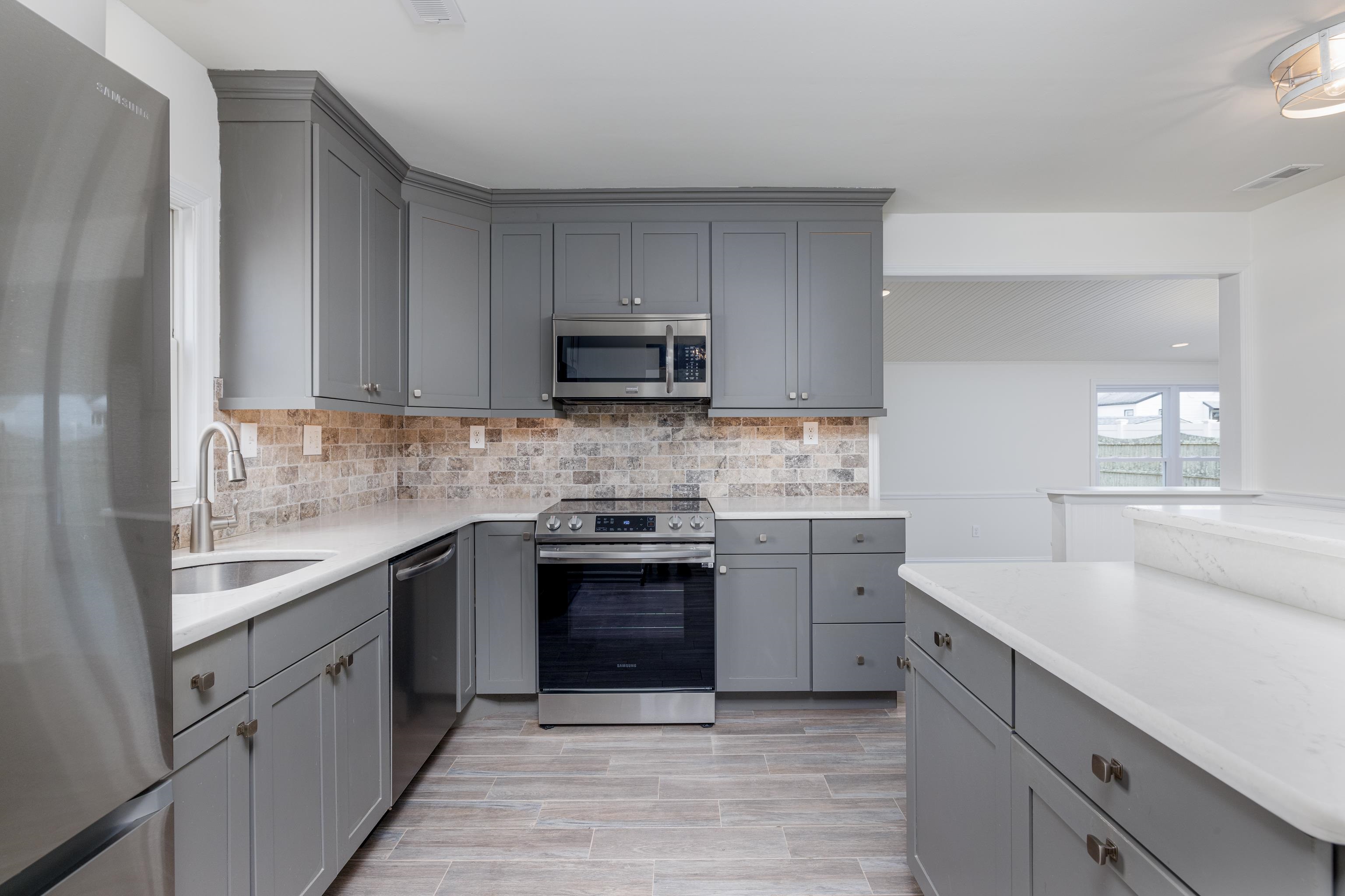 121 Broadway Villas, NJ 08251 - Photo 7 of 32 a kitchen with stainless steel appliances granite countertop a sink stove and refrigerator