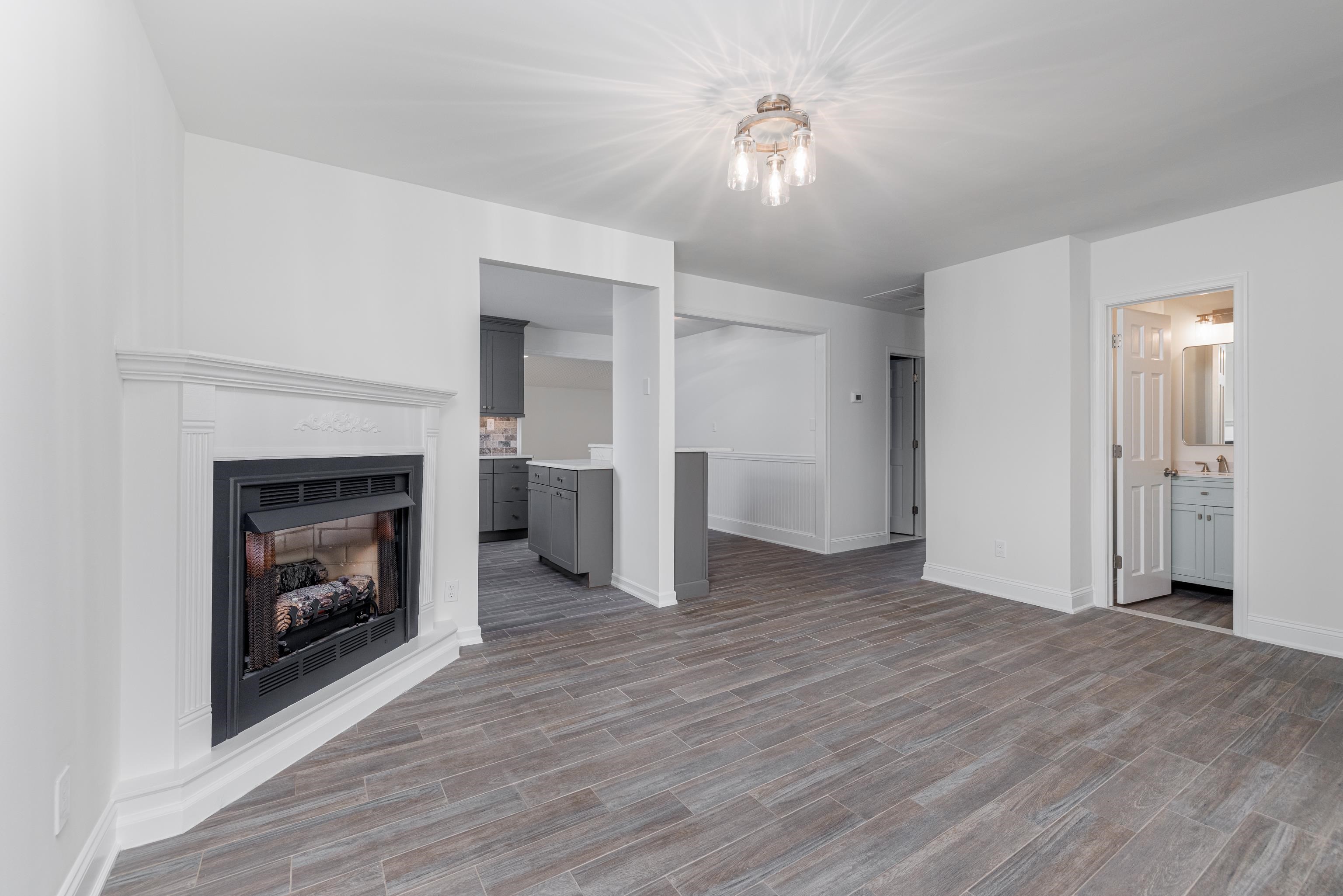 121 Broadway Villas, NJ 08251 - Photo 10 of 32 a view of an empty room with wooden floor fireplace and a window