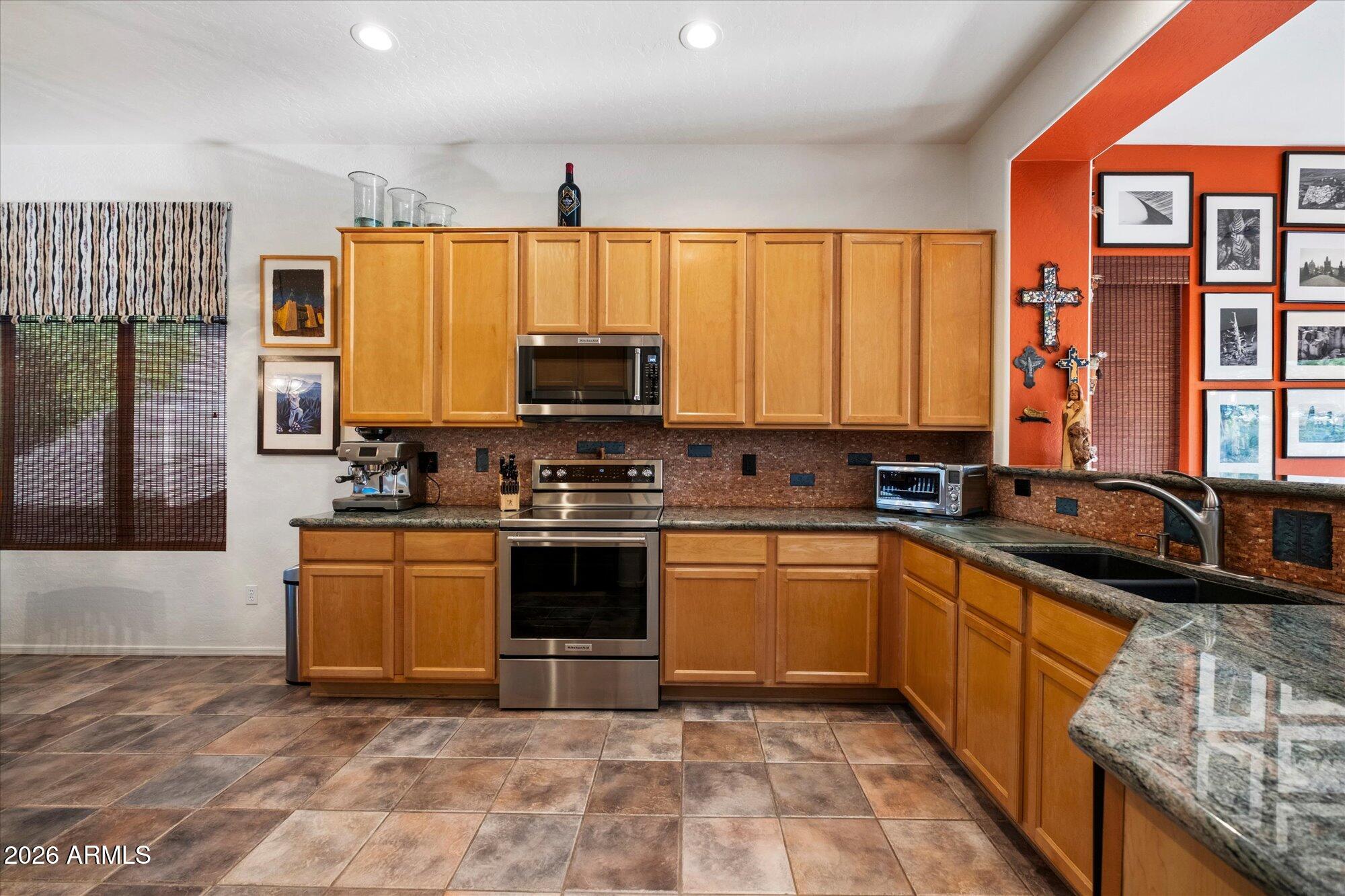 5025 East Kirkland Road Phoenix, AZ 85054 - Photo 14 of 37 a kitchen with stainless steel appliances granite countertop a stove a sink and a microwave