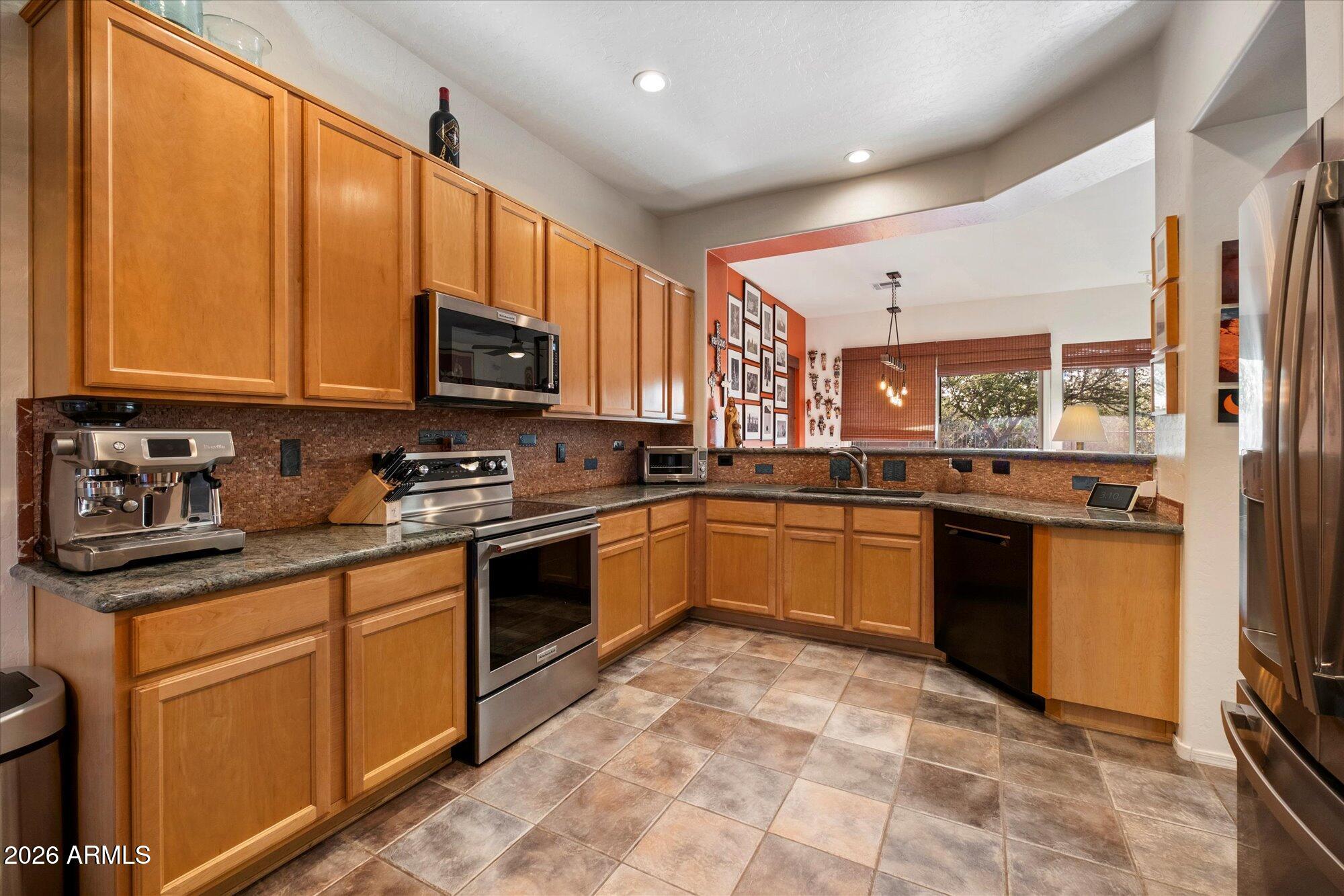 5025 East Kirkland Road Phoenix, AZ 85054 - Photo 15 of 37 a kitchen with stainless steel appliances granite countertop a stove a sink dishwasher and a refrigerator