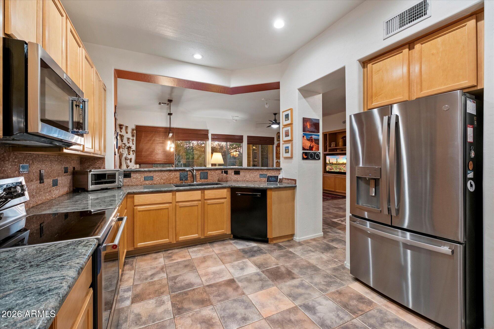 5025 East Kirkland Road Phoenix, AZ 85054 - Photo 16 of 37 a kitchen with stainless steel appliances granite countertop a refrigerator a stove top oven a sink and dishwasher