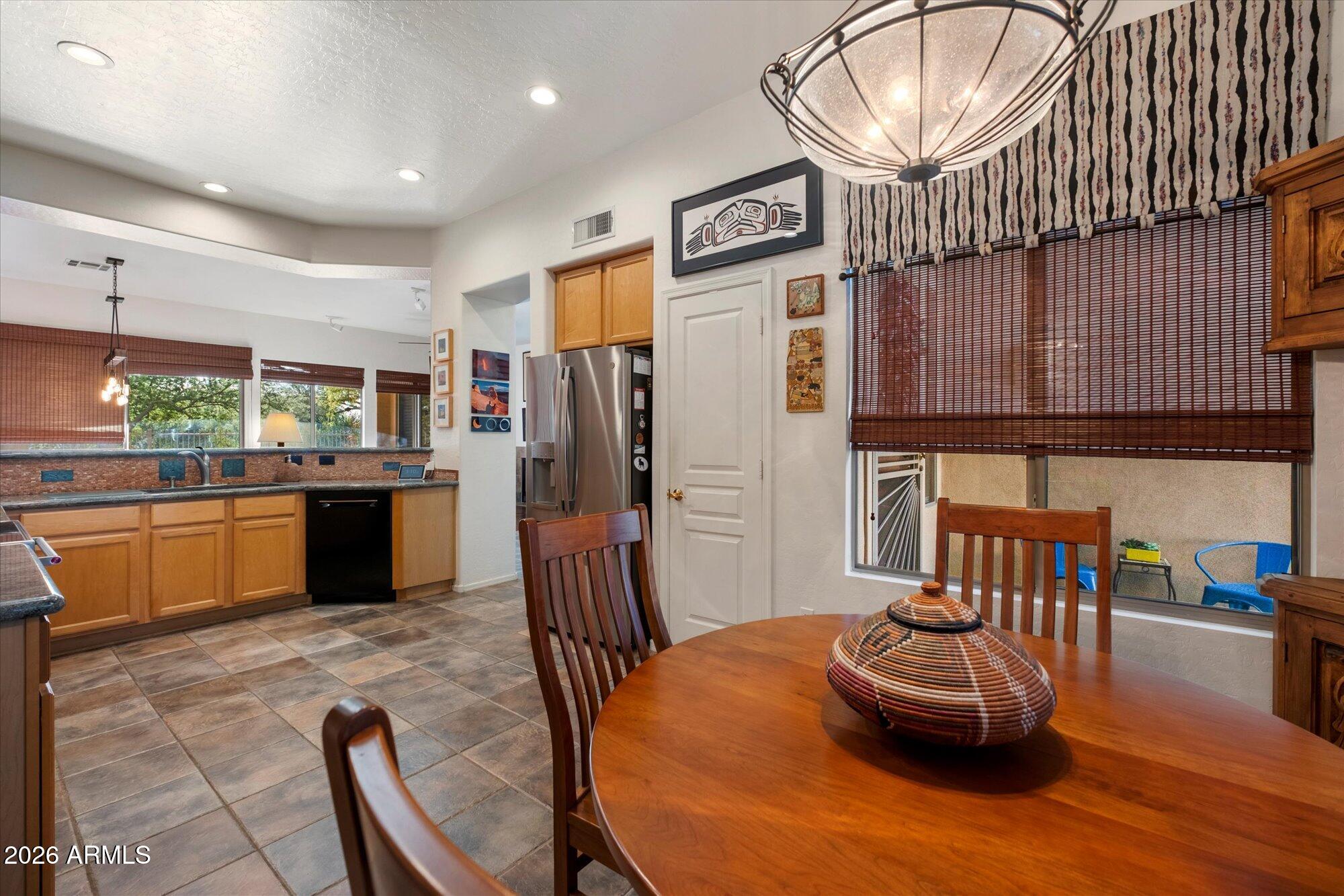 5025 East Kirkland Road Phoenix, AZ 85054 - Photo 18 of 37 a kitchen with stainless steel appliances kitchen island granite countertop a table chairs in it and wooden floors