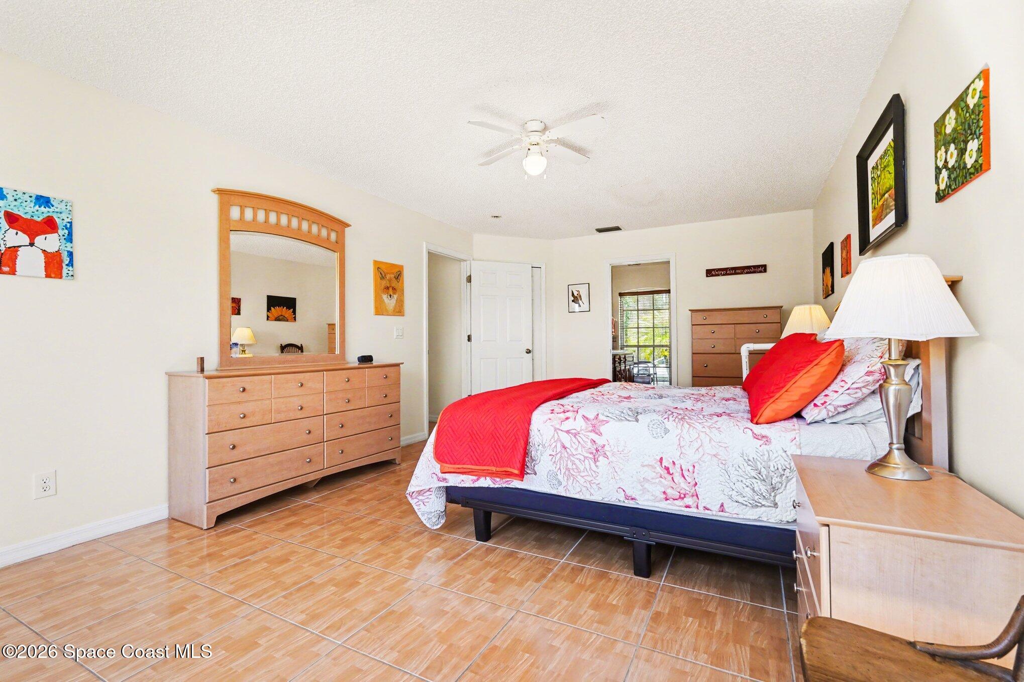 938 Commerce Road Southeast Palm Bay, FL 32909 - Photo 19 of 31 a bedroom with a bed and a dresser