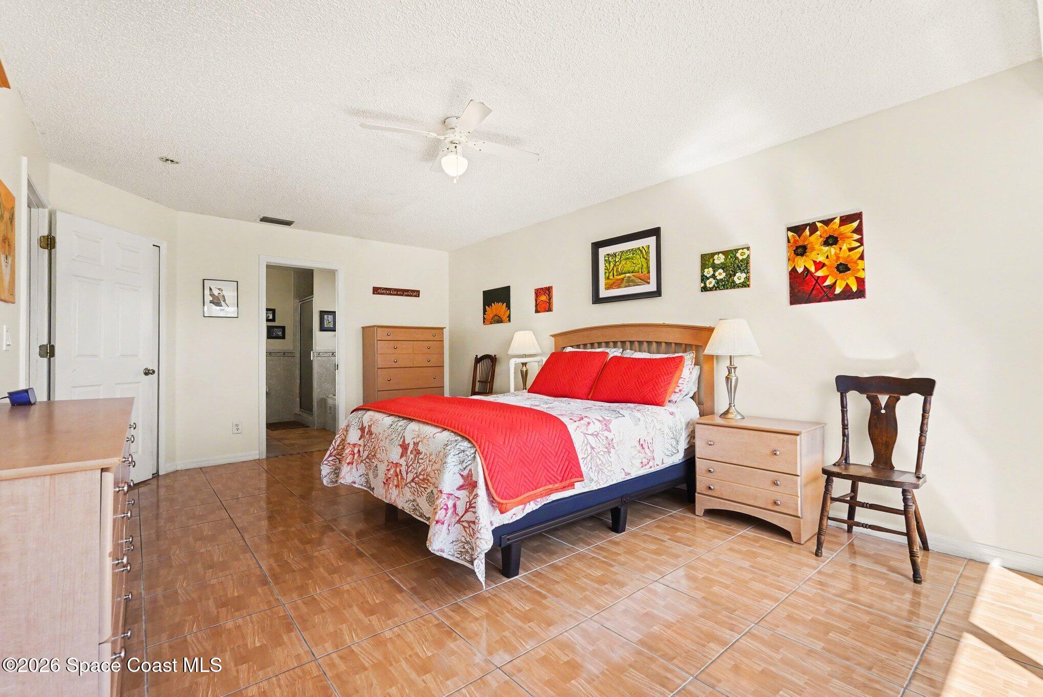 938 Commerce Road Southeast Palm Bay, FL 32909 - Photo 20 of 31 a bedroom with a bed and a chandelier