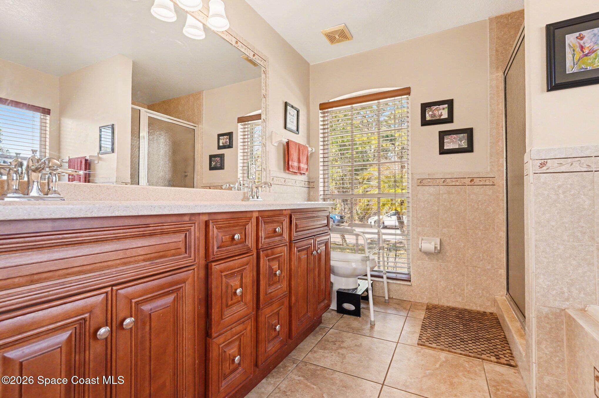 938 Commerce Road Southeast Palm Bay, FL 32909 - Photo 22 of 31 a bathroom with a sink a mirror and a shower