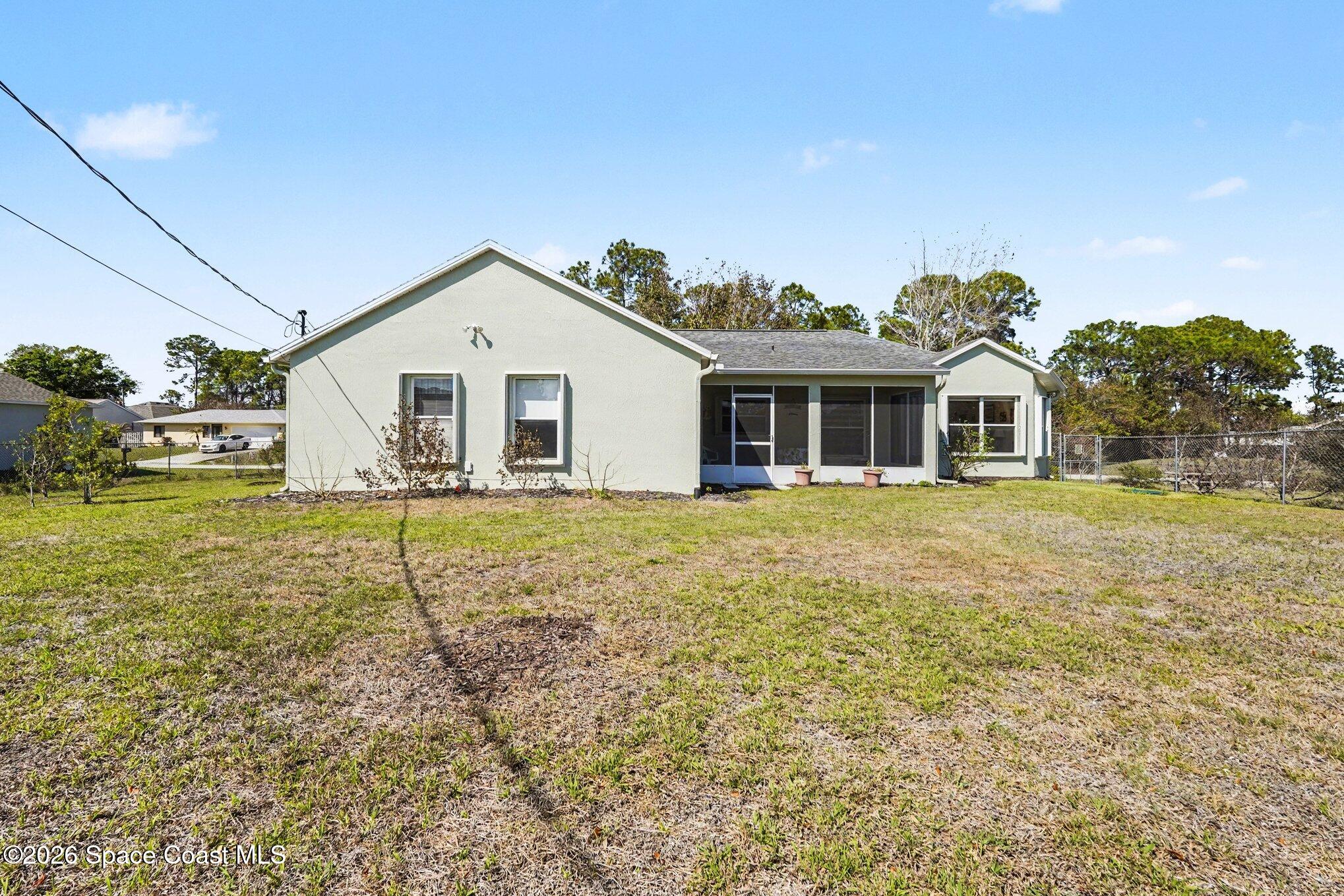 938 Commerce Road Southeast Palm Bay, FL 32909 - Photo 26 of 31 a front view of a house with a garden and trees
