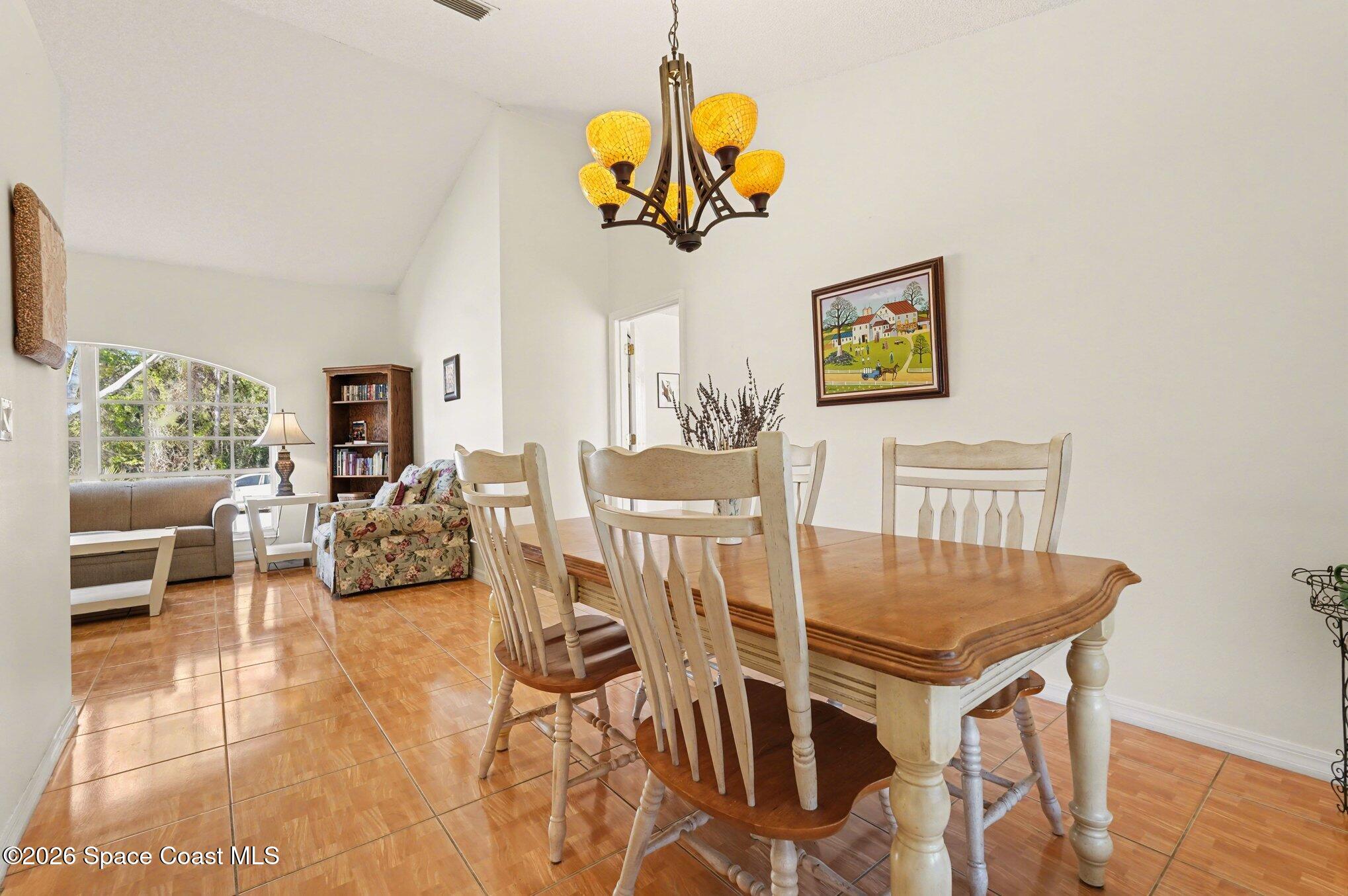 938 Commerce Road Southeast Palm Bay, FL 32909 - Photo 5 of 31 a view of a dining room with furniture and chandelier