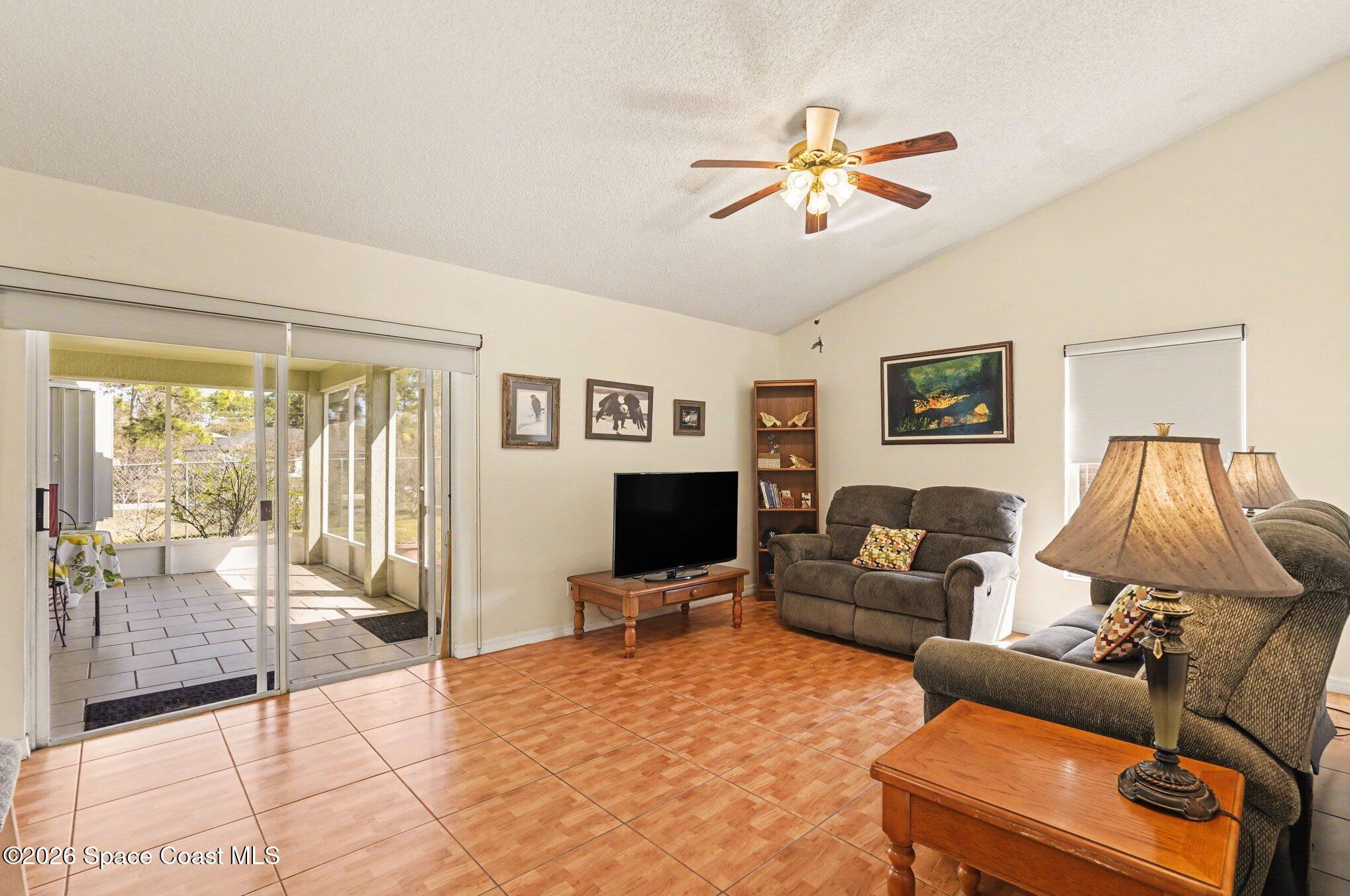 938 Commerce Road Southeast Palm Bay, FL 32909 - Photo 8 of 31 a living room with furniture and a flat screen tv