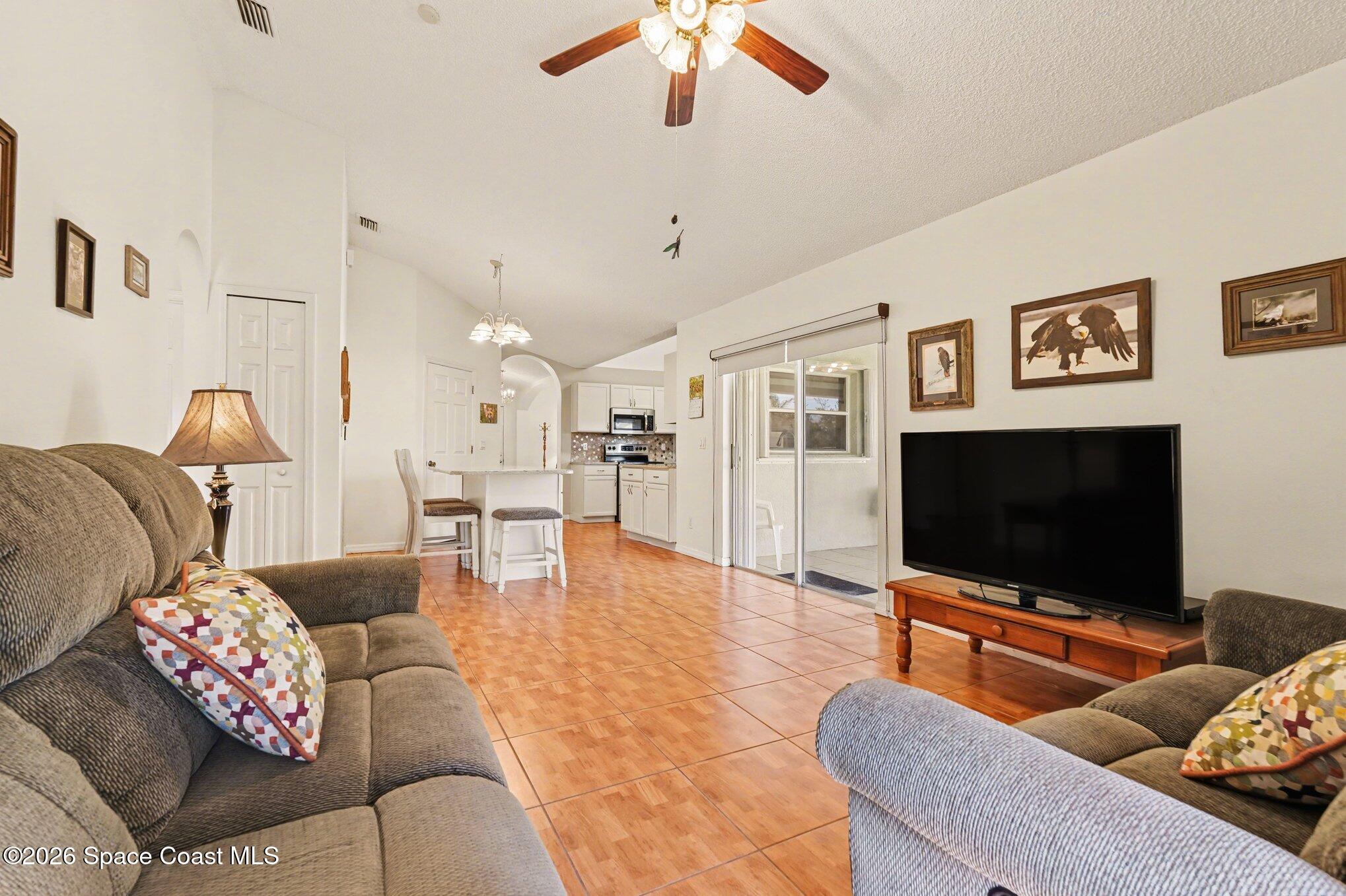 938 Commerce Road Southeast Palm Bay, FL 32909 - Photo 9 of 31 a living room with furniture and a flat screen tv