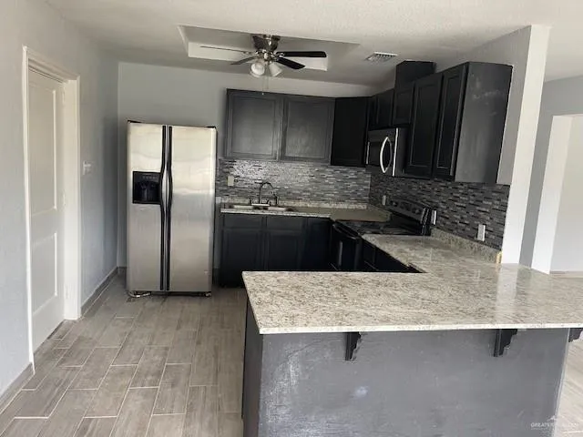 a kitchen with stainless steel appliances granite countertop a sink and a refrigerator